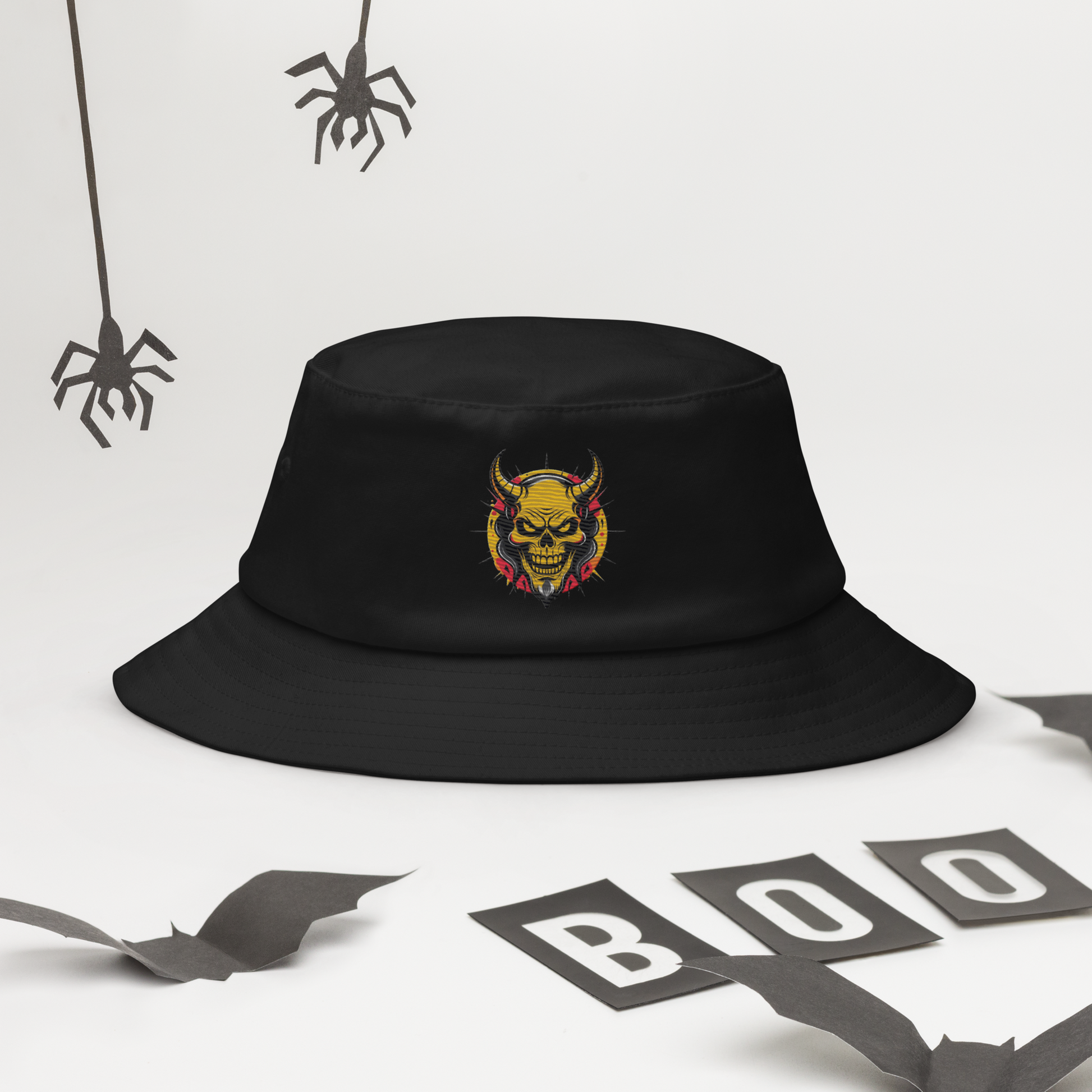 The Orange Devil Bucket Hat in black with bold embroidered graffiti devil design, shown from front view on neutral background
