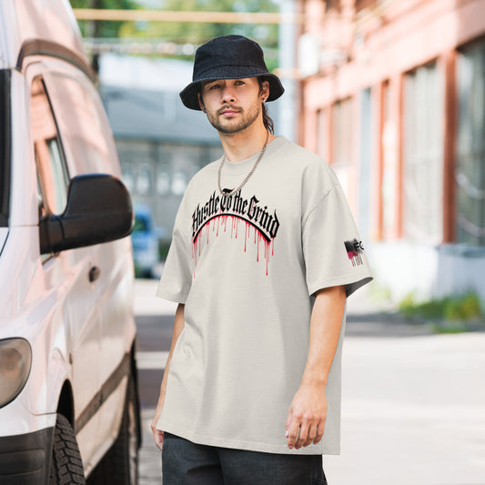 Oversized unisex “Hustle To the Grind” T-shirt in faded white, showcasing urban graffiti streetwear design.
