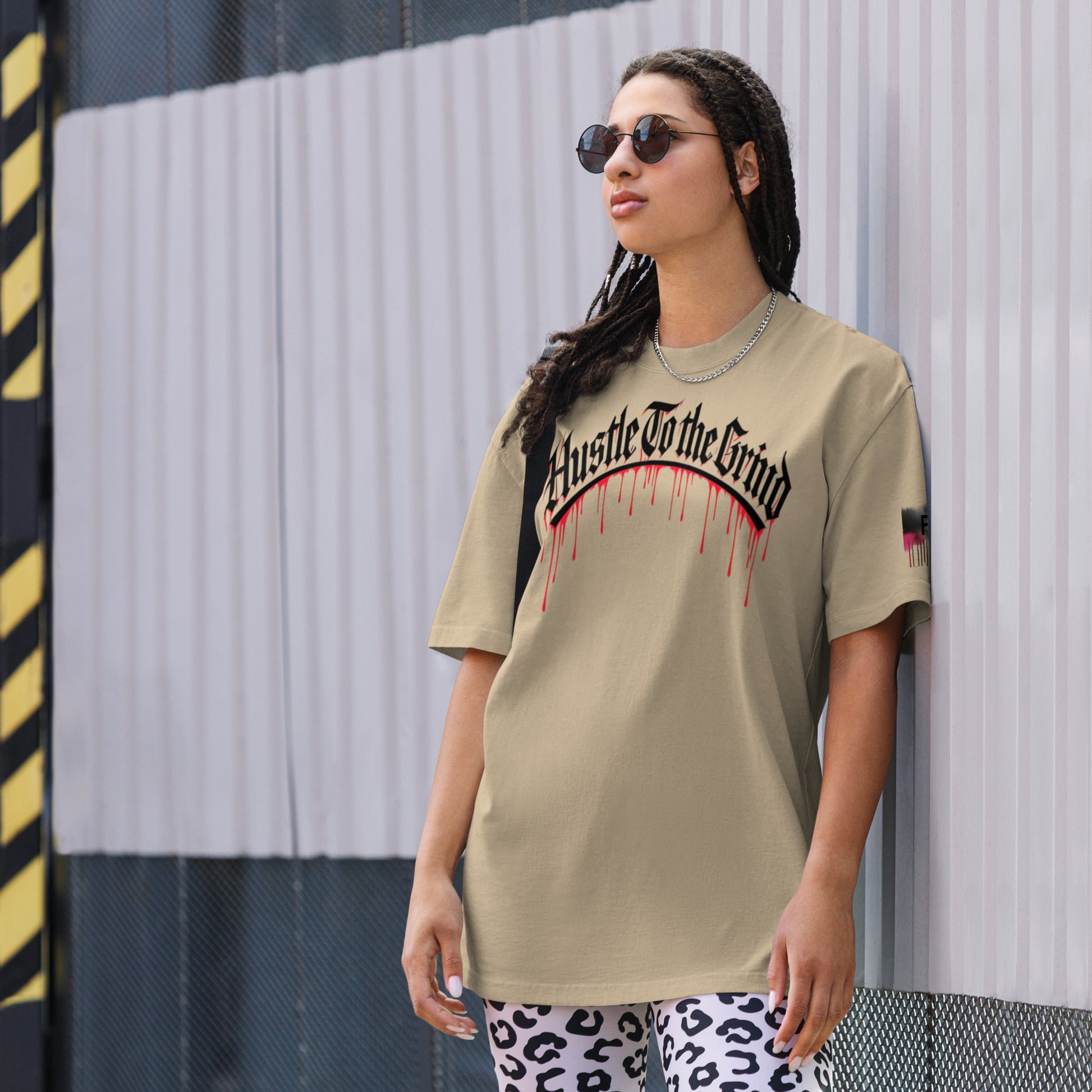 Oversized unisex T-shirt in faded bone color, featuring “Hustle to the Grind” streetwear graphic.
